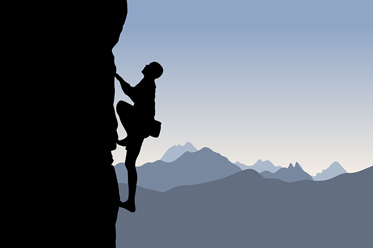 Silhouette of a person rock climbing