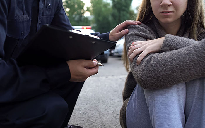 police officer comforting teen girl